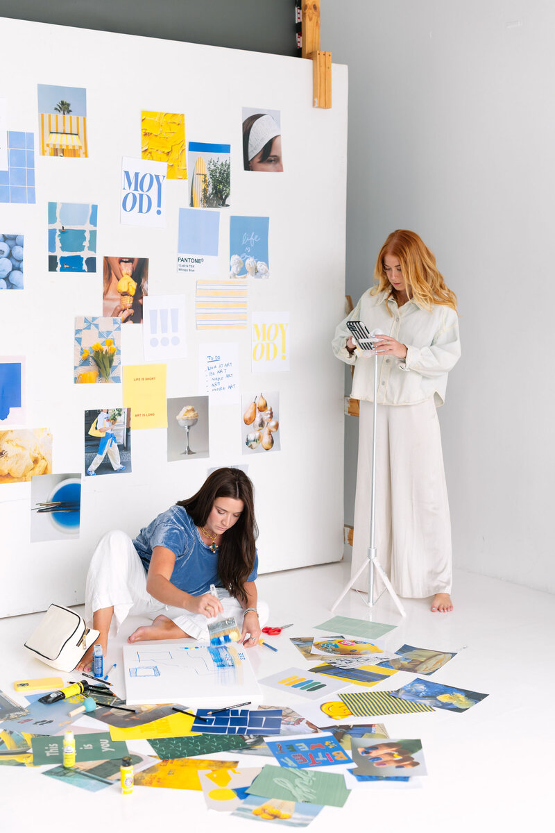 ALT: Grace sitting on floor looking at binder of client projects