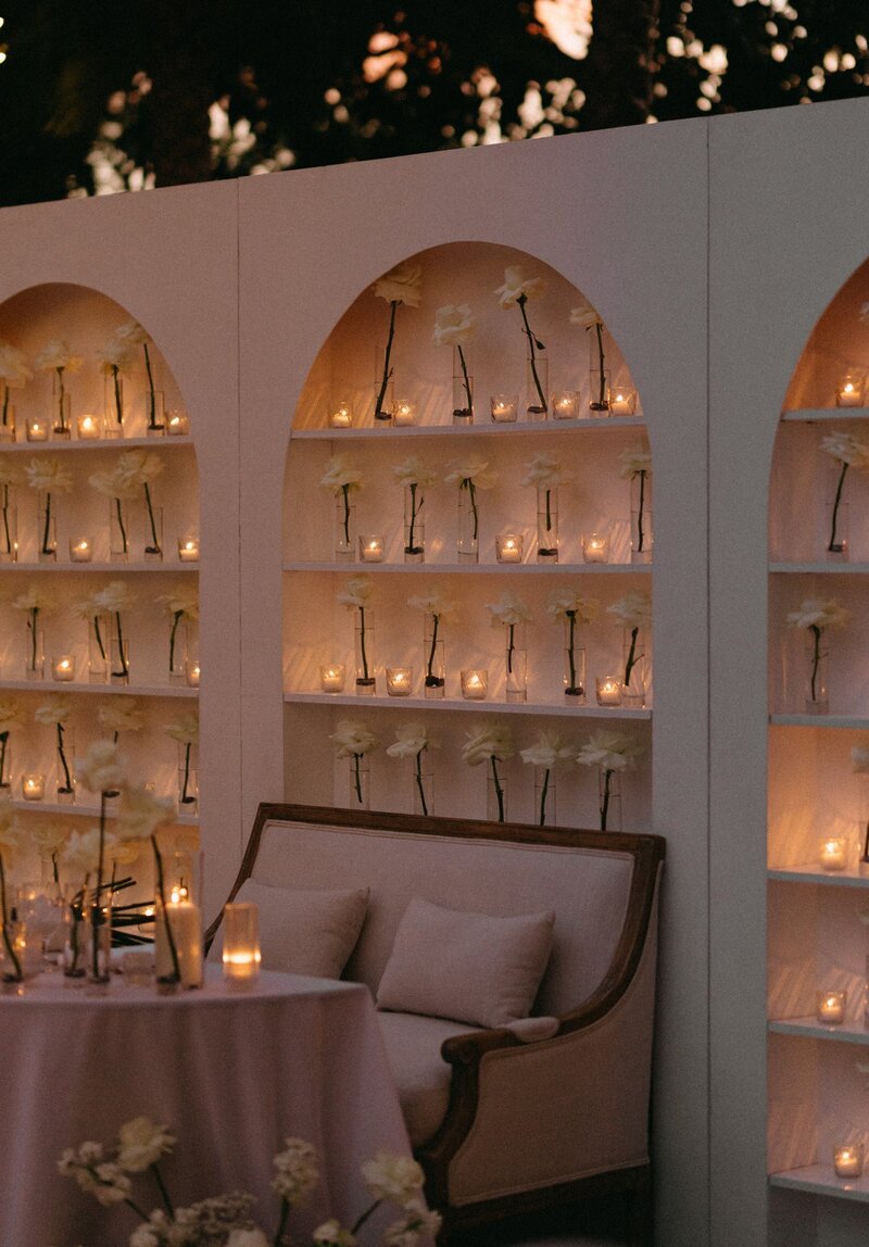 Wedding sweetheart table with candles and floral vases wall backdrop