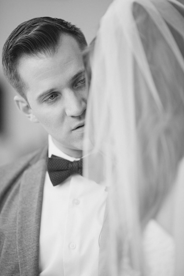 Black and white photo of a groom looking at a bride