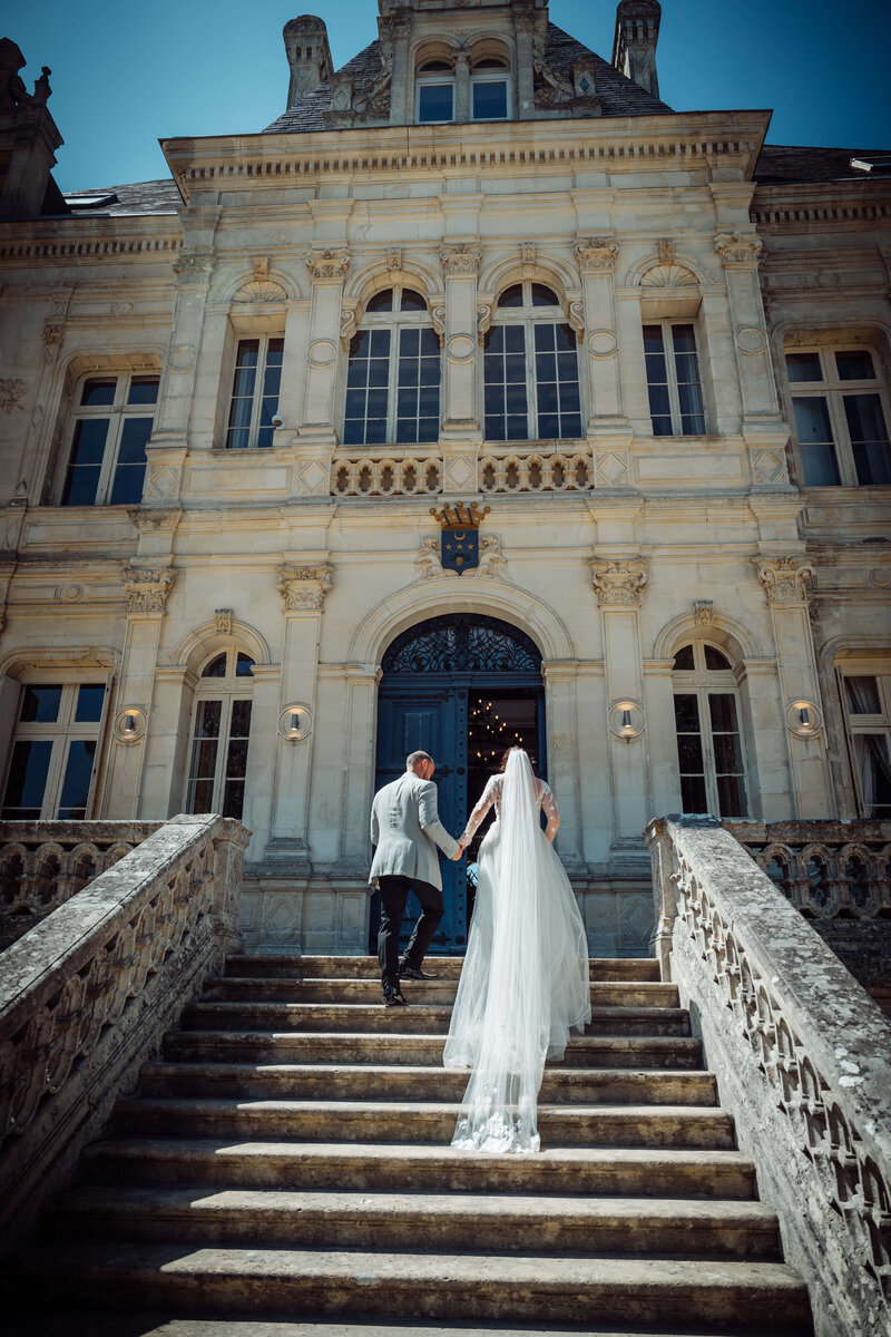 wedding-couple-walking-upstairs-chateaudelavalouze