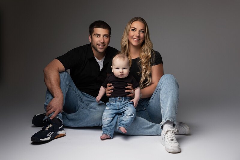Family sitting in photo studio looking at family photographer nj
