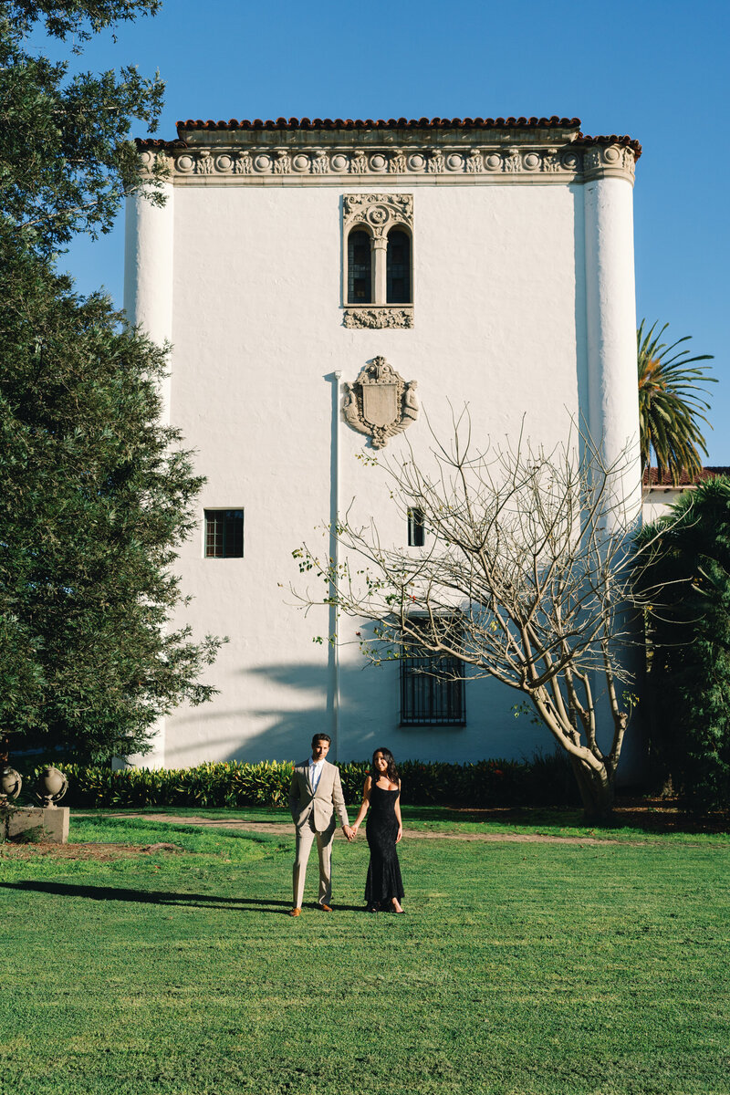 couple hold hands at the santa barbara courthouse after their wedding ceremony in the lawn