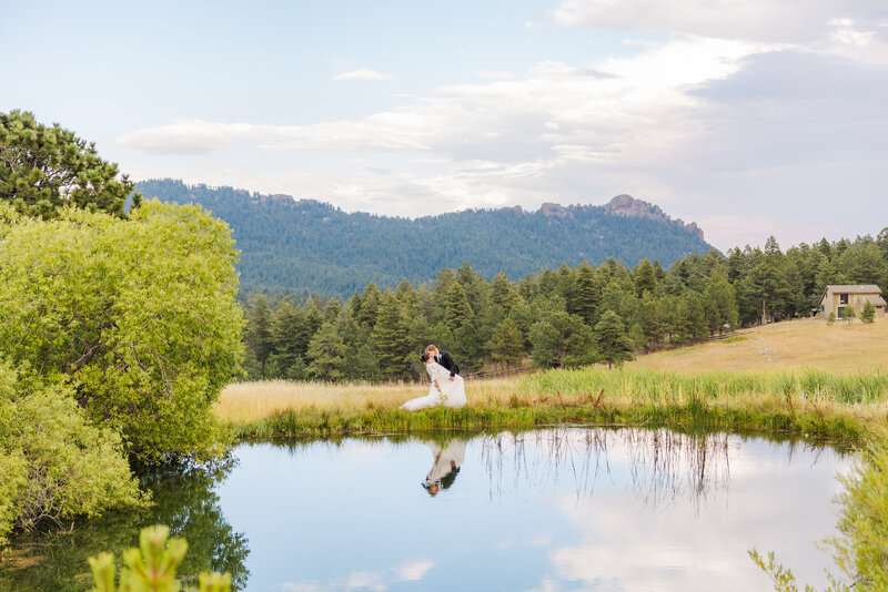 Bride and groom sharing a romantic kiss at their wedding in Littleton, Colorado at the Arrowhead Golf Course with her veil flowing.