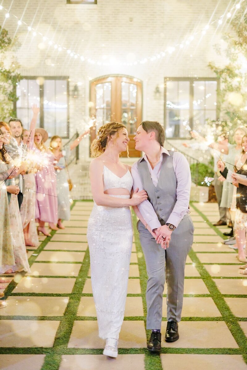 A newlywed couple walks through the Bradford's courtyard, surrounded by sparkelrs.