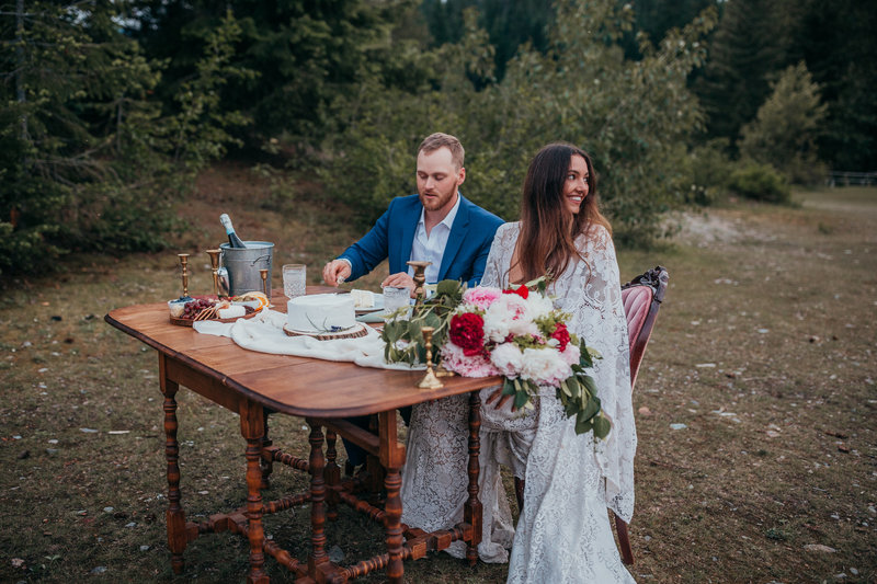 bride and groom sitting at couple table