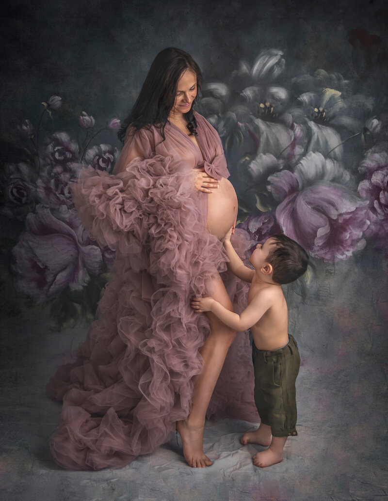 "Son touching his expecting mom's belly during an elegant studio maternity session in Ottawa"