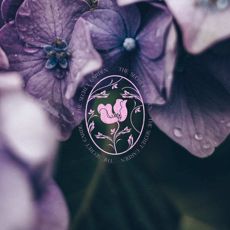 secret garden logo with a flower over a photography background of hydrangeas