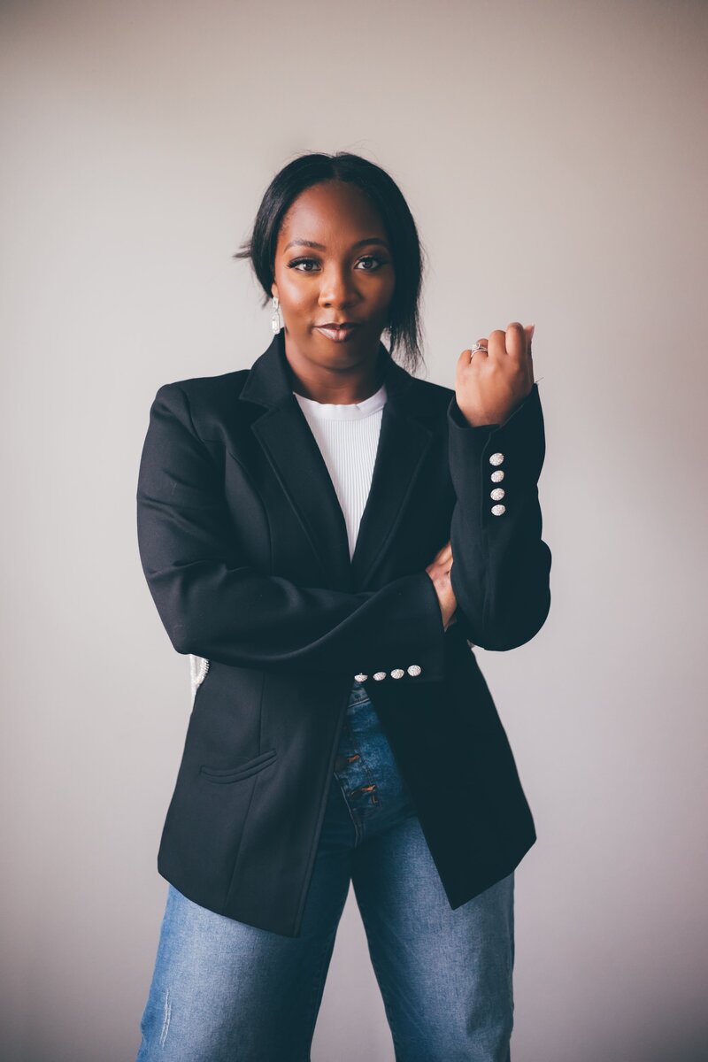 A black woman in jeans and a blazer posing for a photo for Shreveport personal branding photographer Britt Elizabeth.
