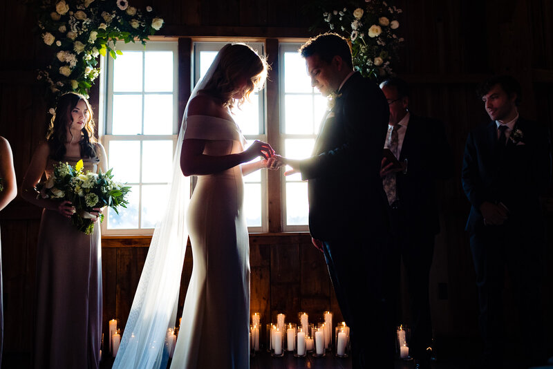 Wedding couple exchanges rings during a candle lit ceremony at Cornman Farms in Michigan