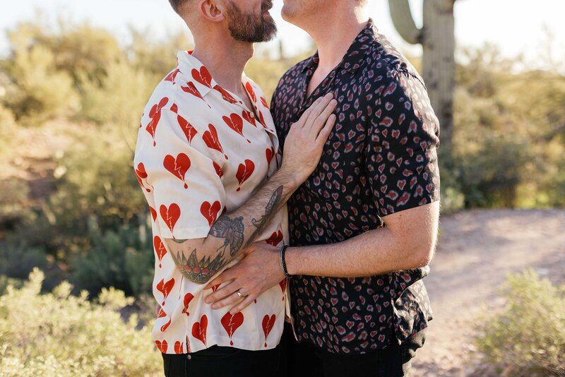 LGBTQ+ couple cuddle for their engagement photos in the desert.