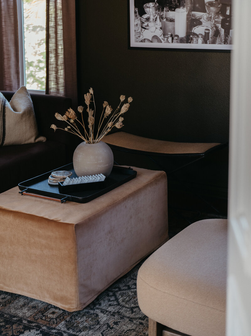 Neutral-toned living room vignette with velvet ottoman, ceramic vase, and layered textures — styled by Natalie Barnas Interiors, a modern interior designer serving La Jolla, Solana Beach, Del Mar, and Encinitas, California.