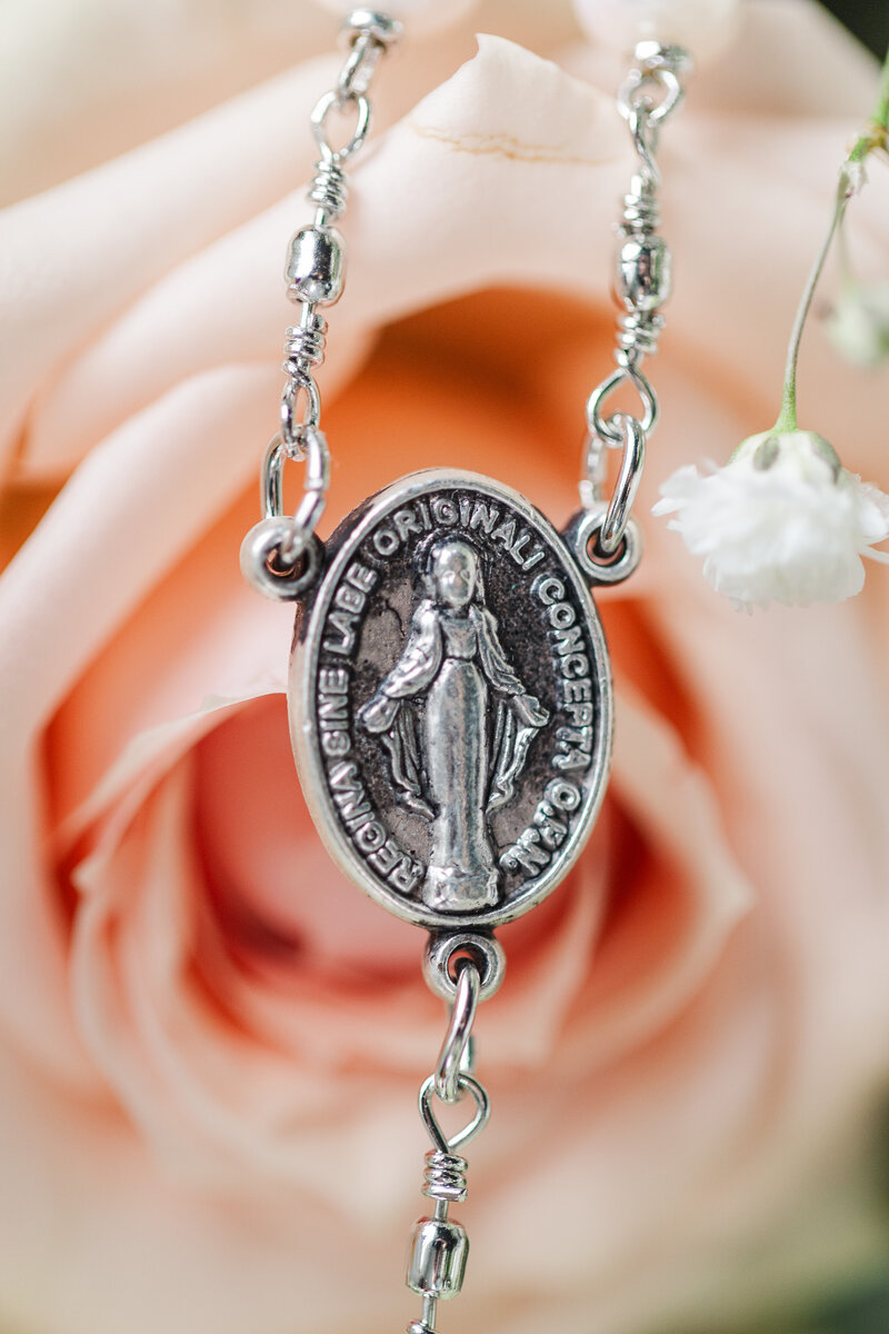close up of a pendant that is attached to rosary beads