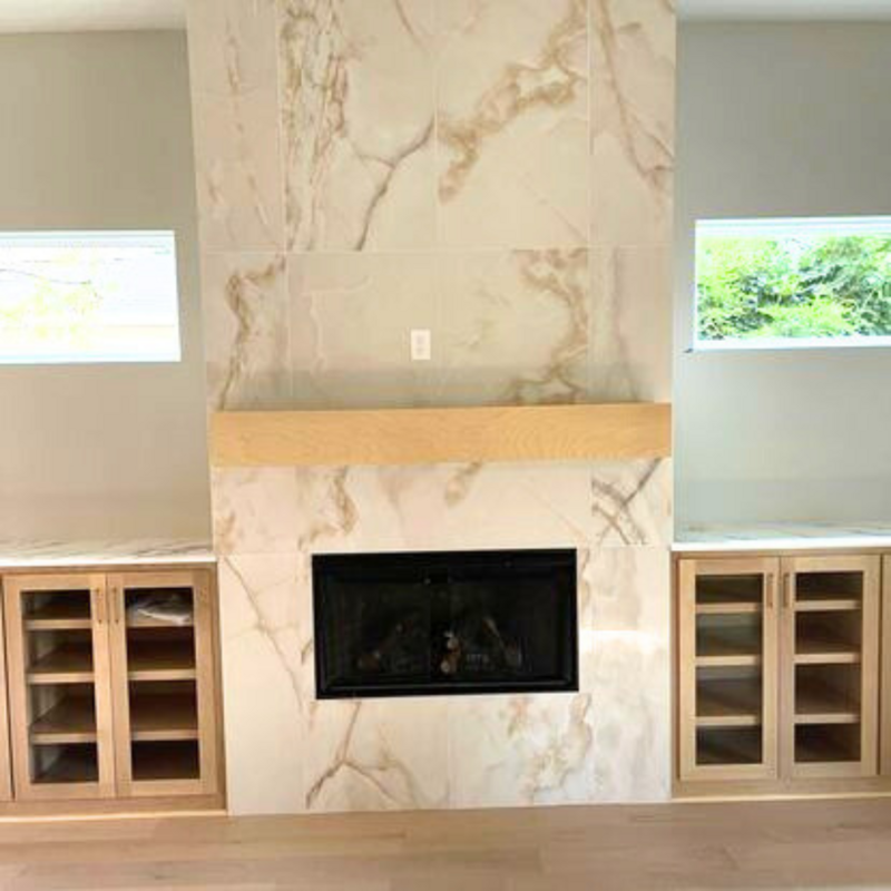 A fireplace with a marble-like tile.
