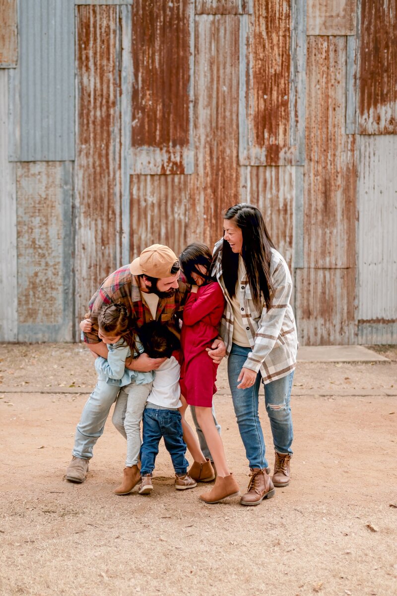 Family of five sharing a fun group hug during lifestyle session in Gruene, TX."