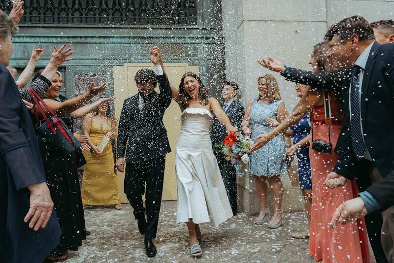 bride and groom coming out of city hall to confetti after eloping shot by Elsie Goodman Photography | NYC Elopement Packages