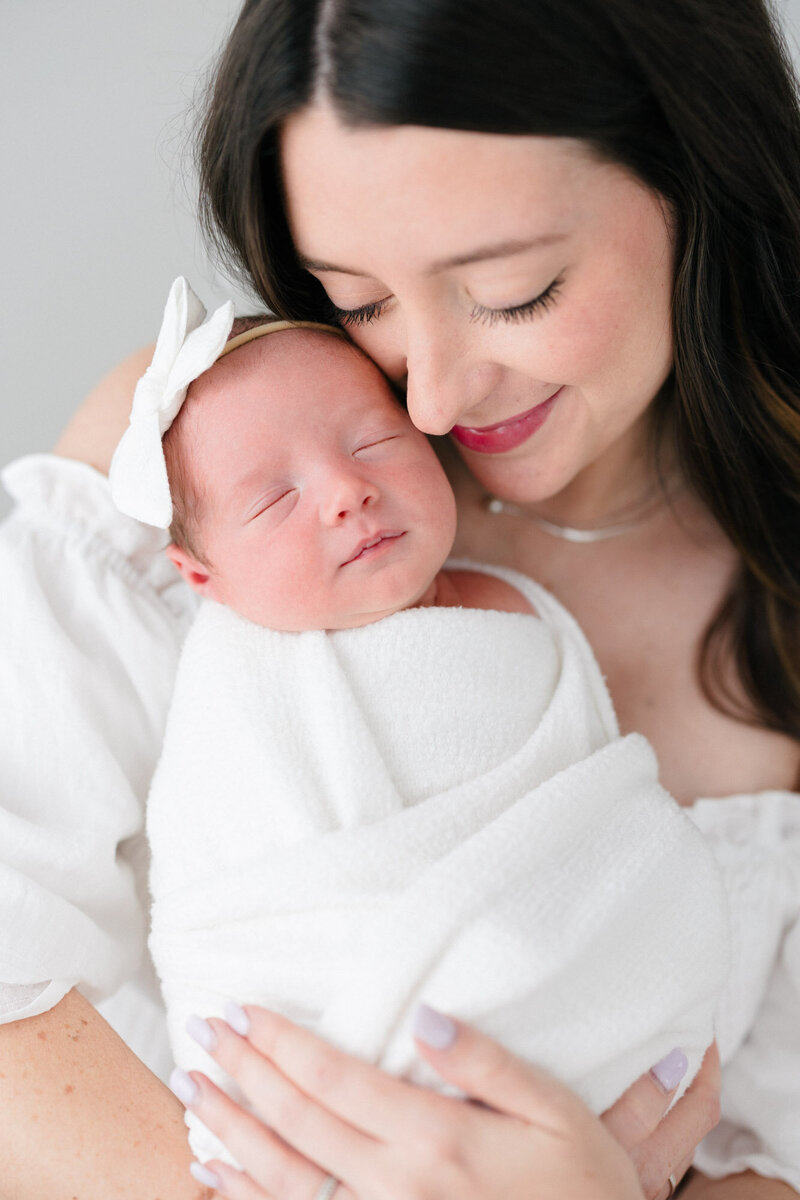 Mom holding her swaddled newborn during her northern kentucky newborn photography session