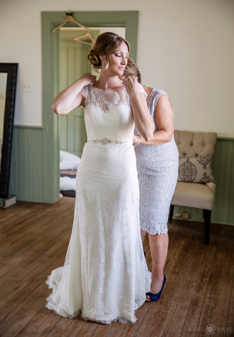 Bride gets dressed at the Deer Creek Schoolhouse at Chatfield Farms