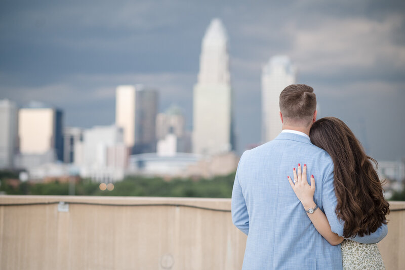Couple embracing during a surprise proposal at Independence Park in Charlotte, NC, captured by DeLong Photography.