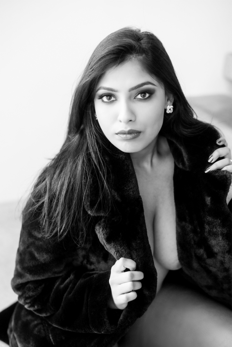 Indian woman sexy pose showing her cleavage in black fur jacket
