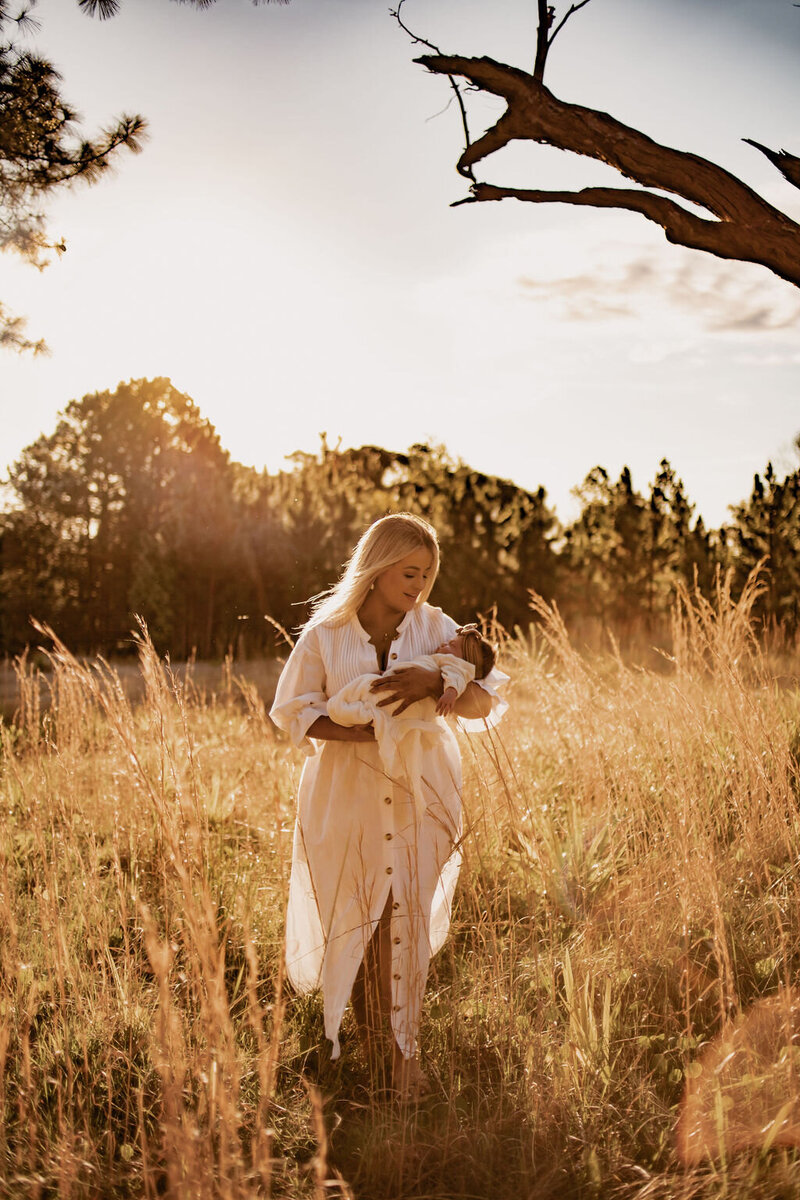 lady holding baby in long grass