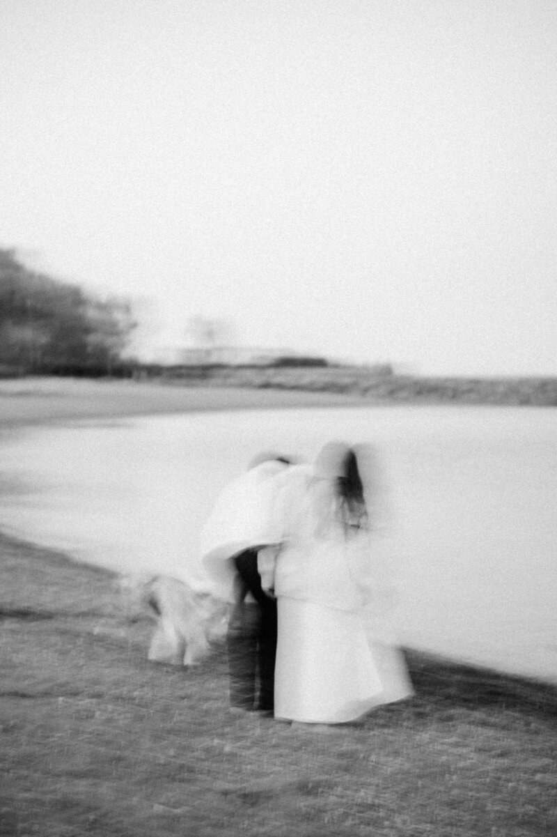 Engaged couple on the beach in toronto having a special moment with their dog.