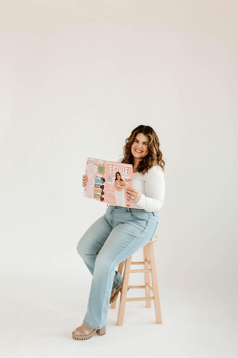 Macayla Hopper holding her custom skincare magazine featuring her esthetic services in Hartselle Alabama