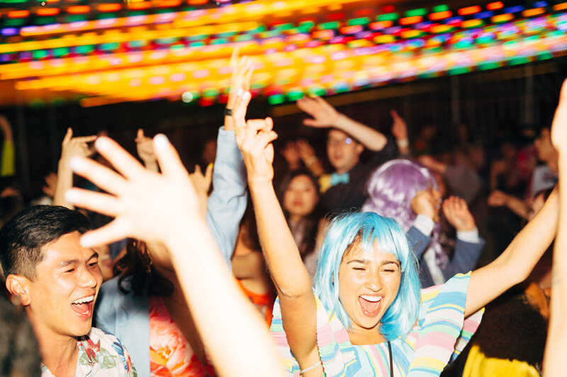 Cheerful and happy wedding guests have fun while dancing at the reception at Dos Pueblos Orchid Farm in Santa Barbara, by wedding photographer Megan Lynn of My Sun and Stars Co.