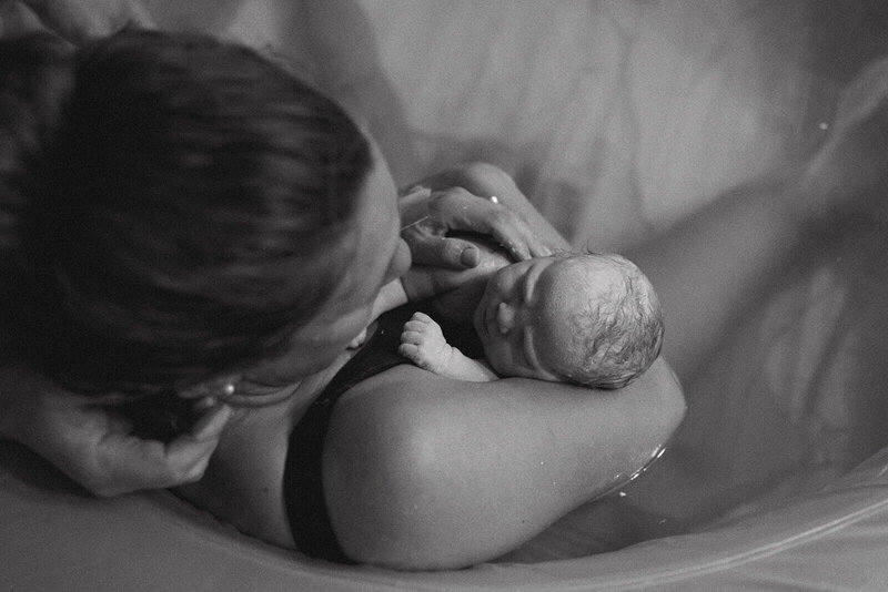 The mother is holding a newborn baby in her arms