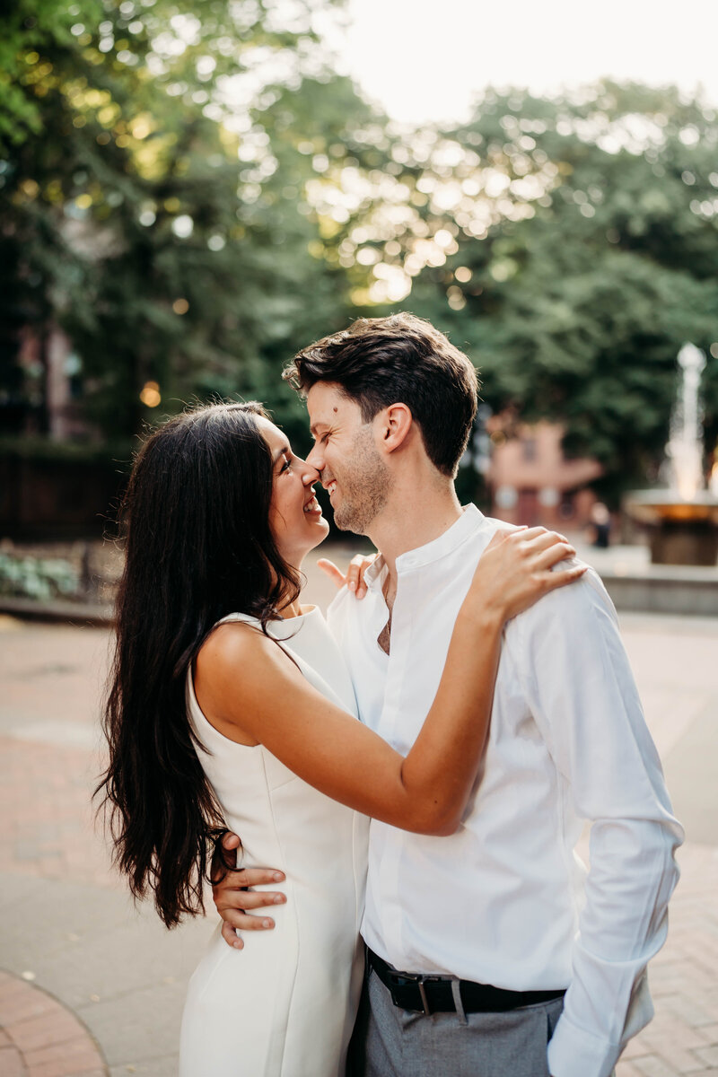 A gentle kiss speaks volumes in this heartfelt engagement photo, set against the timeless brick buildings of the North End.