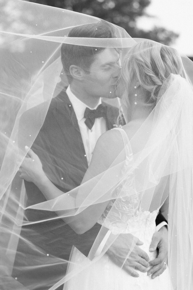 Bride and groom share a romantic veil kiss at Gervasi Vineyard wedding.