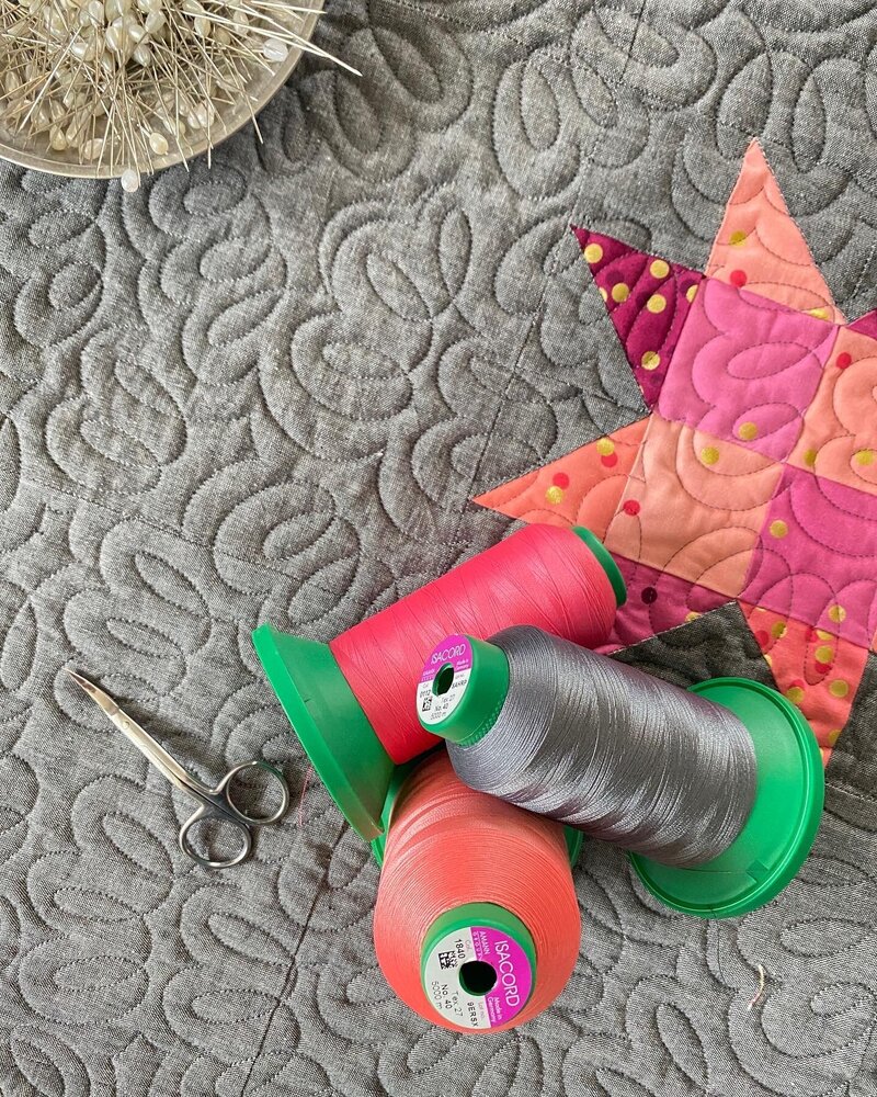 pink star quilt that features the filaments quilting design with pink and grey threads 