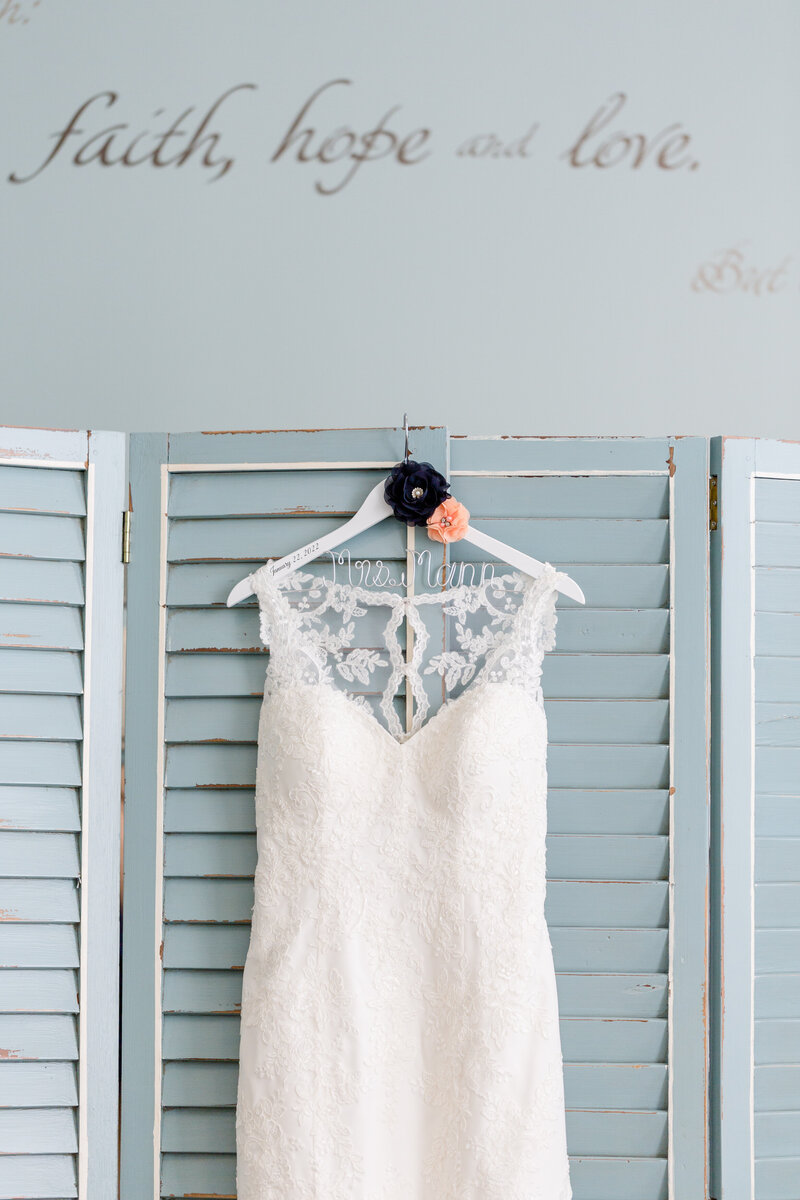 wedding dress hanged in front of a wooden dresser