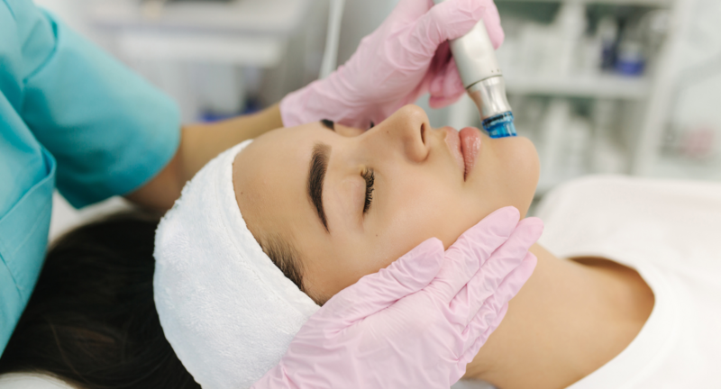 woman has her eyes closed and is receiving a hydrafacial.