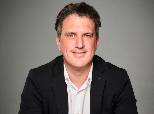 Segelyacht von oben auf dem Meer in tükisblauen Wasser und vier Menschen auf Luftmatratzen im Wasser