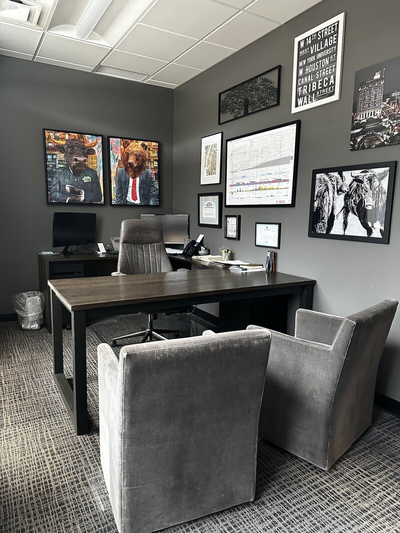 Office space with grey chairs and wooden desk.