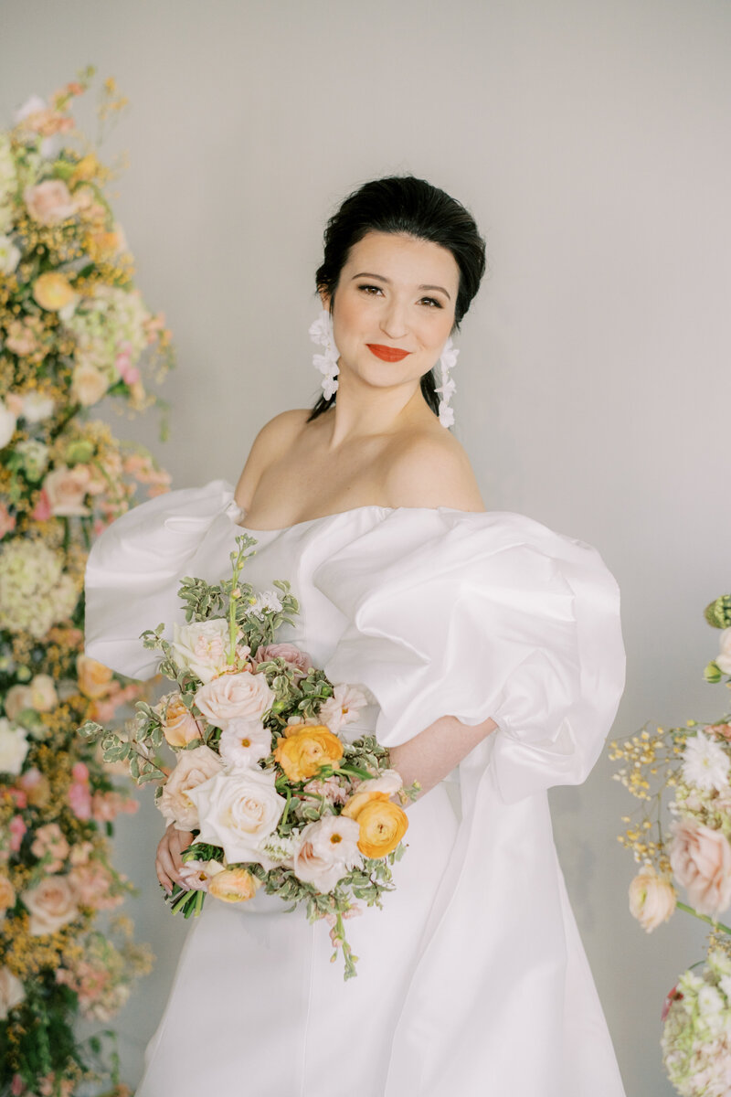 asian bride in Monique Lhuillier gown with orange flowers surrounding her