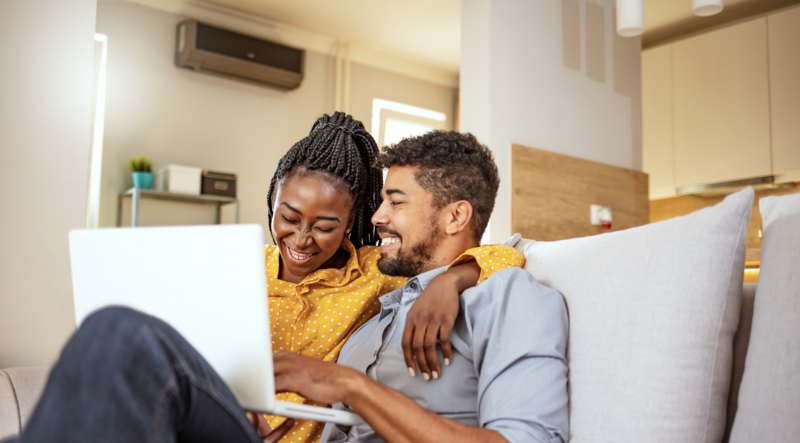 Photo of Couple on couch looking at laptop