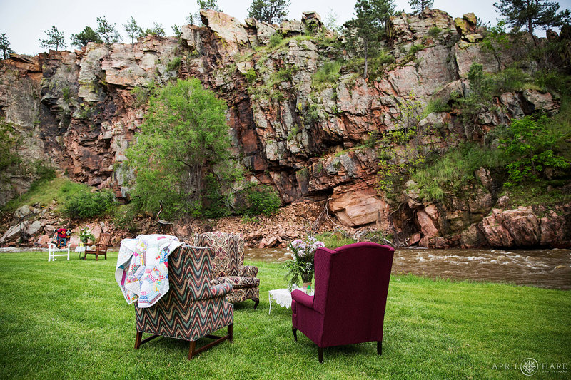 Comfy seating on the lawn with views of the red rock click next to Saint Vrain River at Riverbend wedding venue in Lyons Colorado