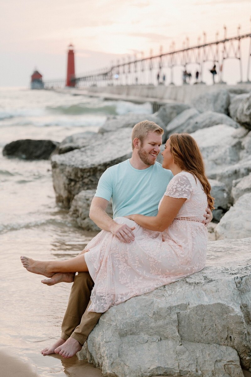 a engaged couple by the pier in Grand Haven taken by a Michigan wedding photographer