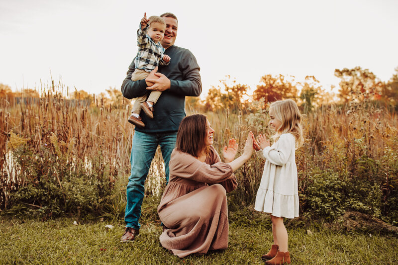 Family session taken in Perrysburg metro park, mom playing witj daughter , dad holding younger son