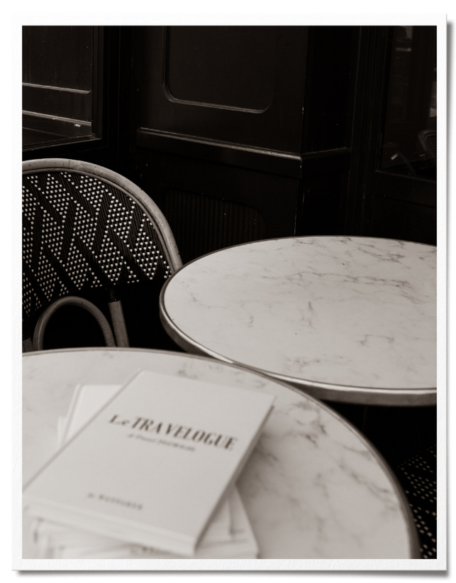 Embossed cream luxury linen travel journal on marble cafe table in Paris