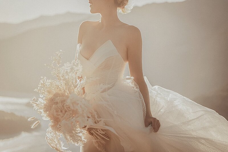 A golden light outdoor photoshoot of a woman wearing a couture dress.