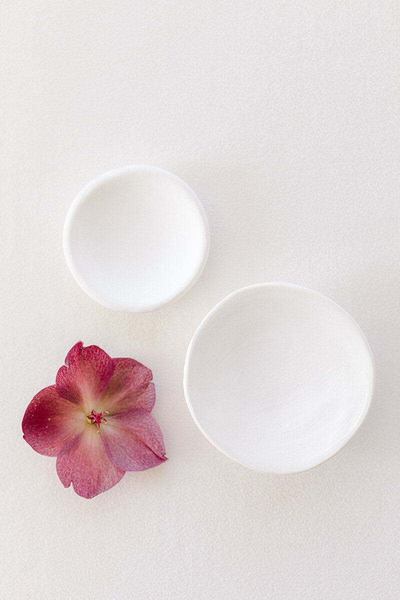Handmade ceramic dishes used to organize accessories in flat lay photography