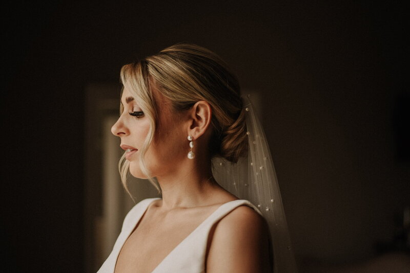 Happy bride looking at makeup and hair in mirror
