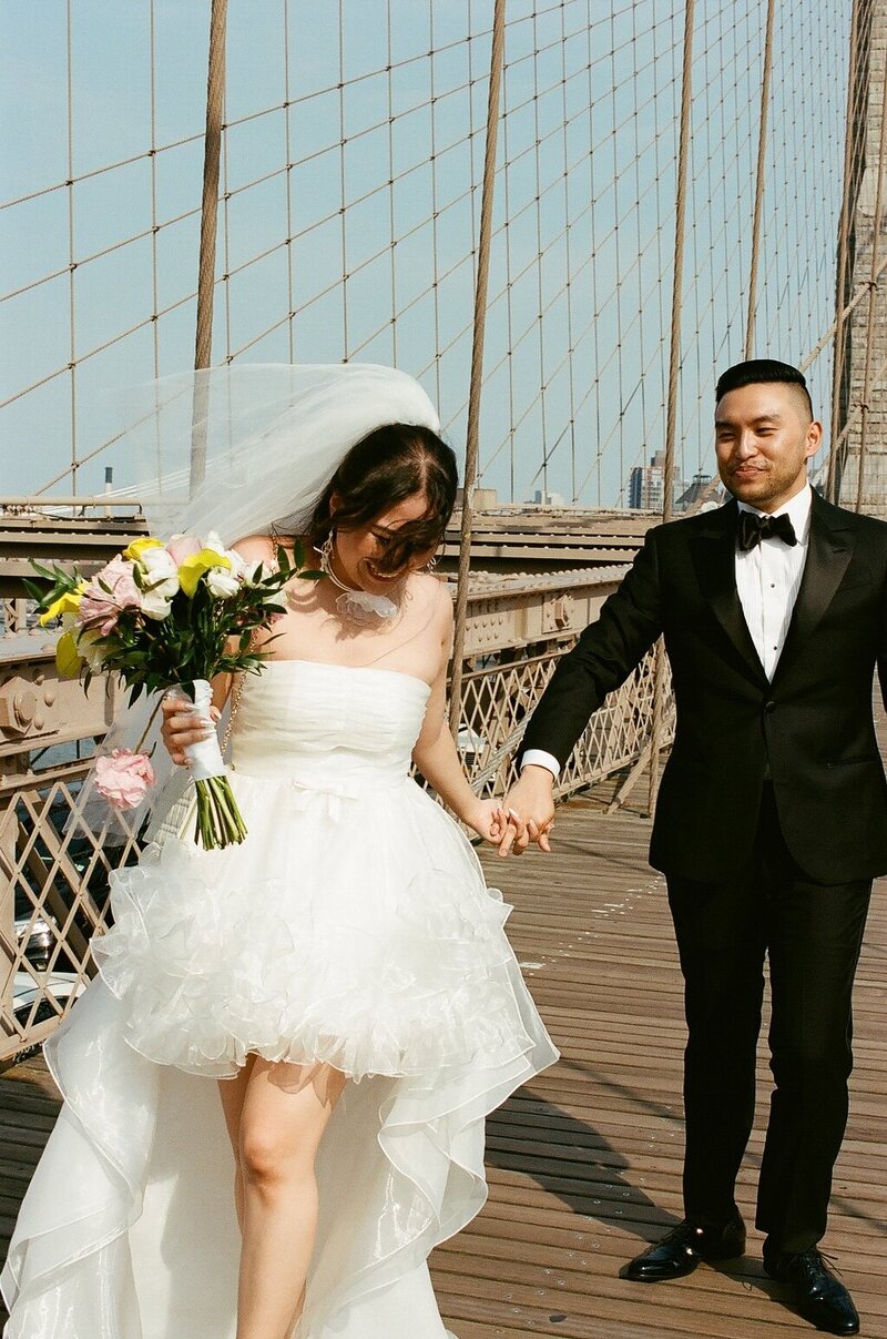 candid film photo of newlyweds on brooklyn bridge