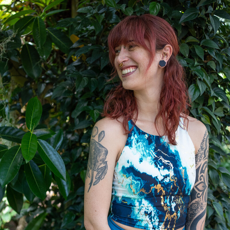 a woman in workout gear looks to the side and wants to help you on your strength journey