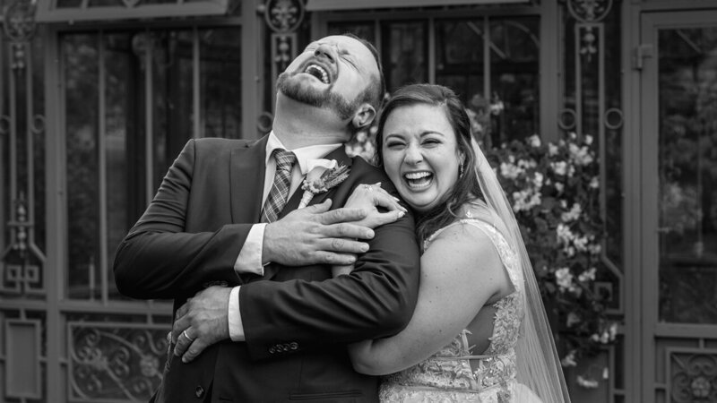 Groom busting up laughing with his bride during their wedding day, a joyful and candid moment captured in real style.