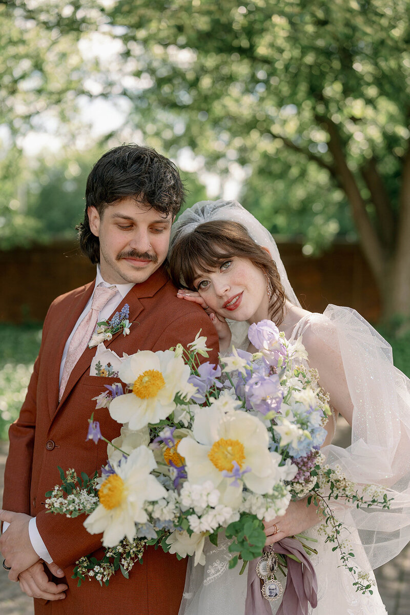 Editorial portrait of couple surrounded by flowers during colorful spring wedding in Michigan.