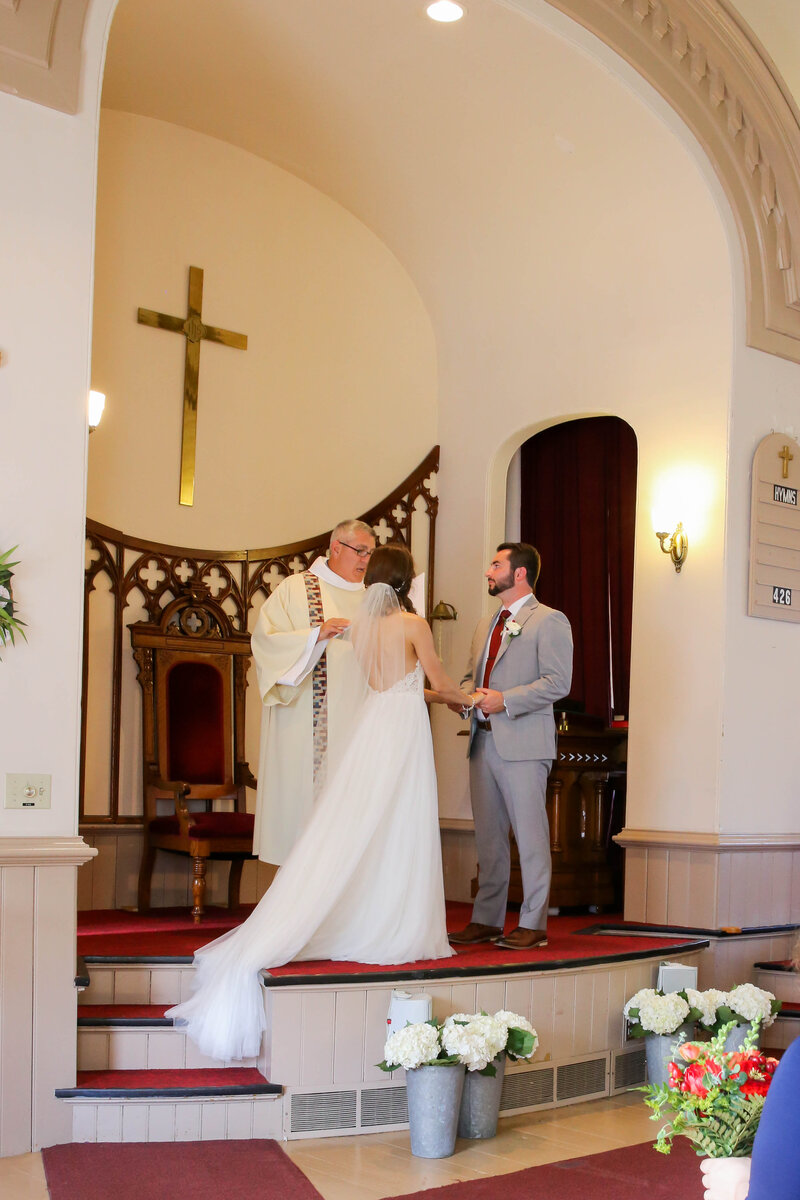 Bride and Groom holding hands at the altar | Acadia Wedding Photography