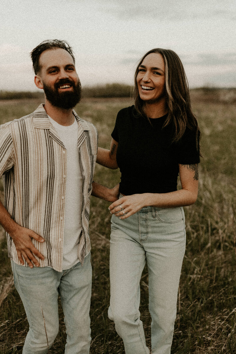 couple walking during engagement photos in an open field in Appleton, Wisconsin
